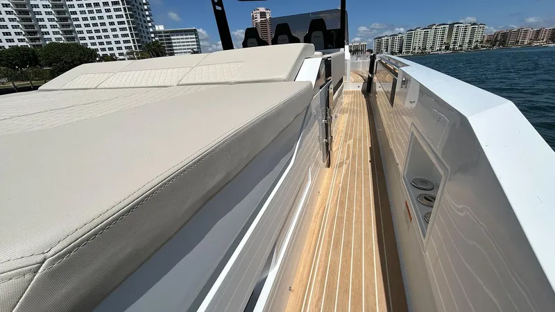 Slide: The Image of 2025 De Antonio Yachts D36 with sleek deck design, cruising near modern waterfront buildings. - 15
