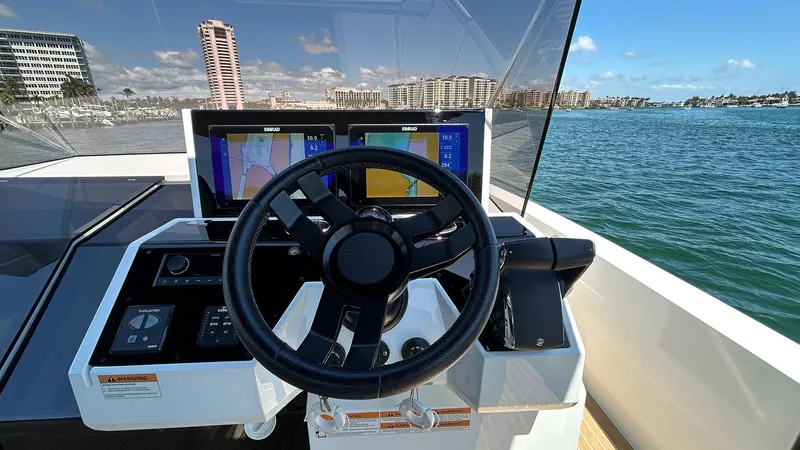 Slide: The Image of 2025 De Antonio Yachts D36 helm with navigation screens, steering wheel, and ocean view. - 6