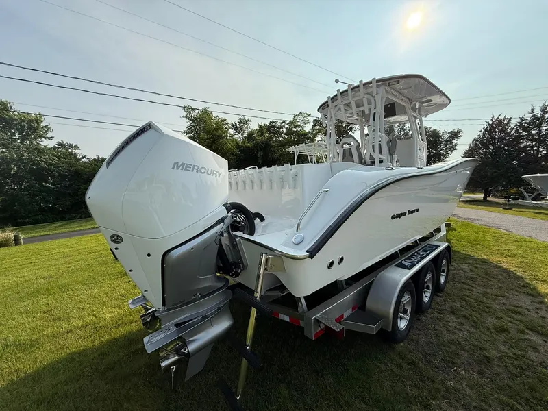 Slide: The Image of 2025 Cape Horn 32 XS boat with Mercury engine on a trailer, parked on grass. - 3