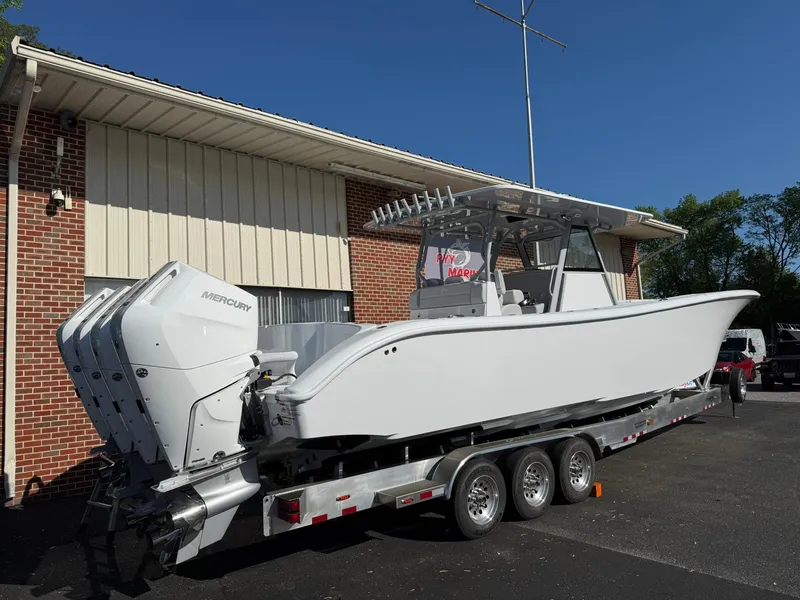 Slide: The Image of 2025 Yellowfin 39 Offshore boat on trailer, parked outside a building. - 1
