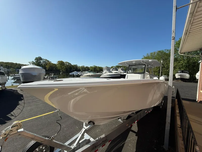 Slide: The Image of 2025 Yellowfin 39 Offshore boat on trailer, parked outdoors under clear blue sky. - 10