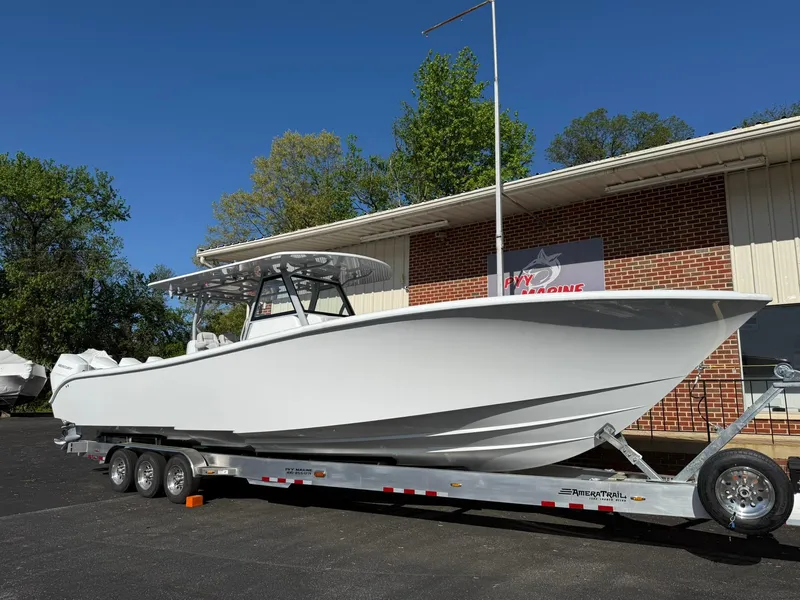 Slide: The Image of 2025 Yellowfin 39 Offshore boat on a trailer, parked outside a brick building. - 9