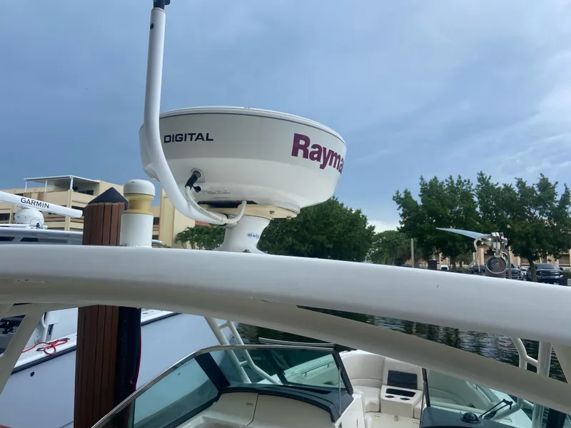 Slide: The Image of Boston Whaler 270 Vantage 2013 with Raymarine radar, docked near trees and buildings. - 11