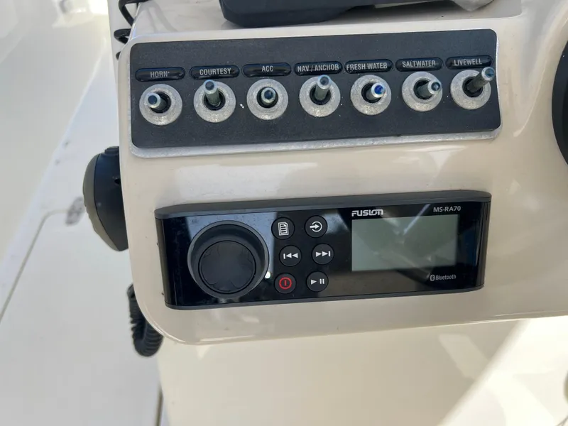 Slide: The Image of Control panel of a 2013 Boston Whaler 270 Vantage boat with switches and Fusion stereo. - 22