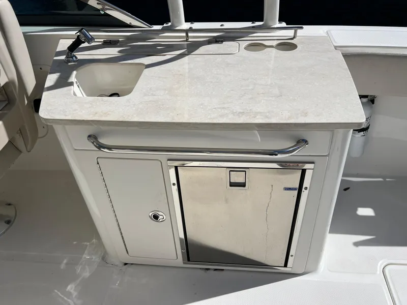 Slide: The Image of Boston Whaler 270 Vantage 2013 boat kitchenette with sink and storage. - 27