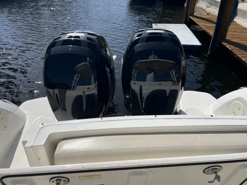 Slide: The Image of Twin outboard engines on a 2013 Boston Whaler 270 Vantage boat at a dock. - 28