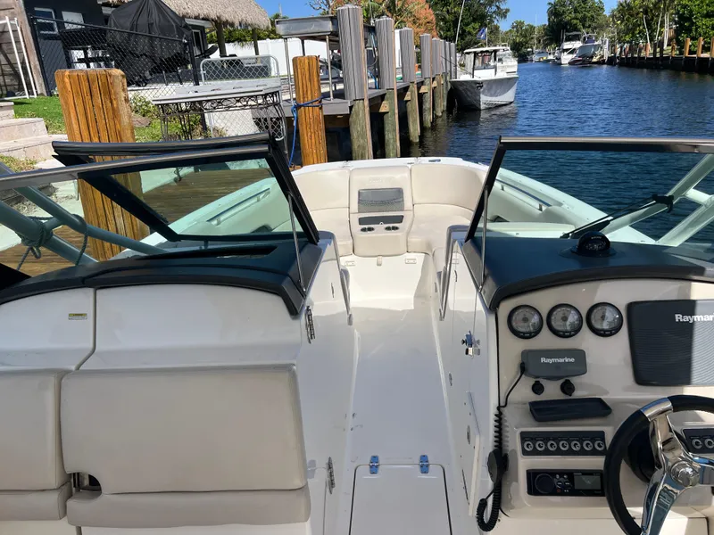 Slide: The Image of 2013 Boston Whaler 270 Vantage boat interior with steering console and waterfront view. - 29
