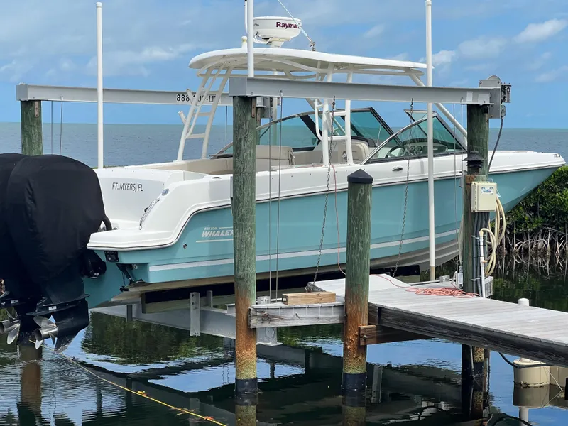 Slide: The Image of 2013 Boston Whaler 270 Vantage boat on lift, docked by the water. - 3