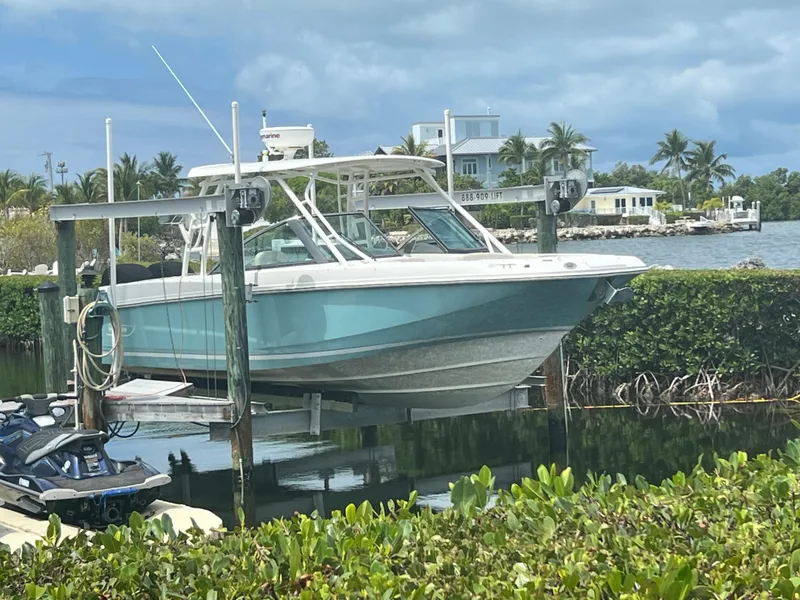 Slide: The Image of 2013 Boston Whaler 270 Vantage boat docked near tropical waterfront homes. - 34