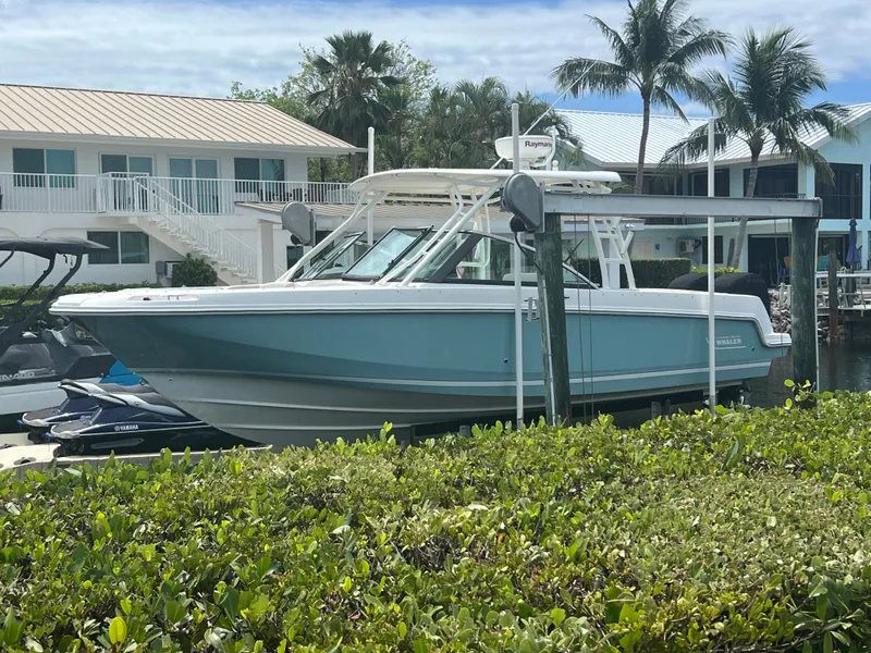 Slide: The Image of 2013 Boston Whaler 270 Vantage boat docked near tropical waterfront homes. - 37