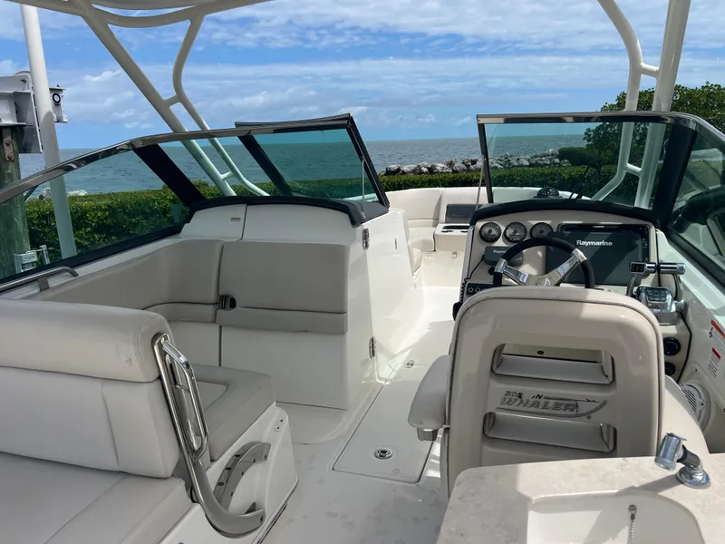 Slide: The Image of 2013 Boston Whaler 270 Vantage boat interior with ocean view, featuring seating and steering console. - 38