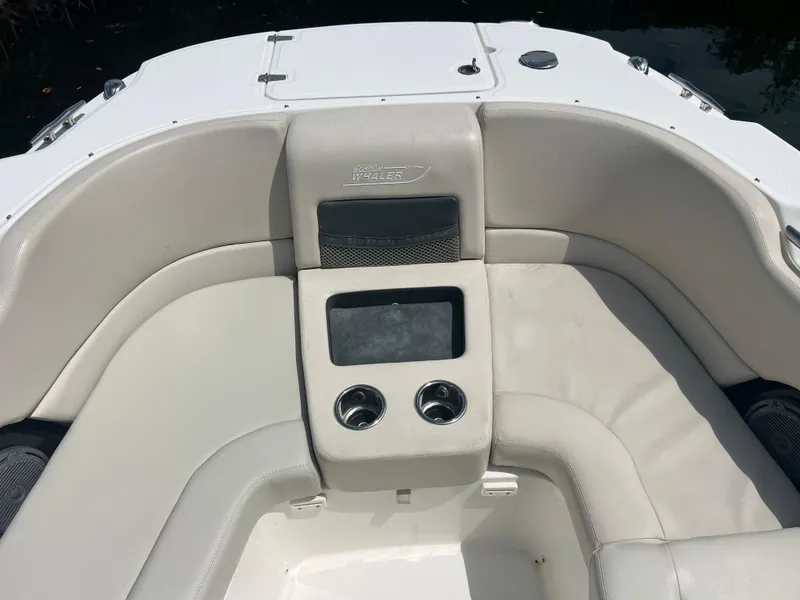 Slide: The Image of 2013 Boston Whaler 270 Vantage boat interior with cushioned seating and cup holders. - 40