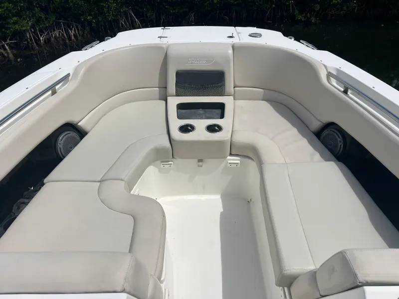 Slide: The Image of 2013 Boston Whaler 270 Vantage boat interior with white cushioned seating and cup holders. - 41