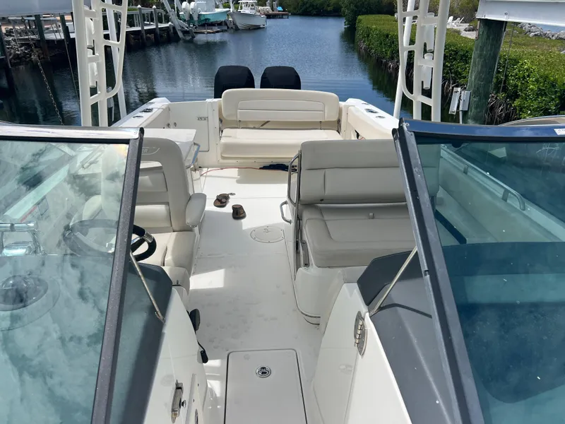 Slide: The Image of 2013 Boston Whaler 270 Vantage boat interior with seating, docked by a serene waterway. - 42