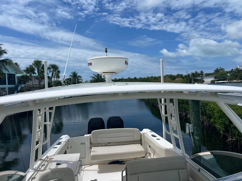 Slide: The Image of 2013 Boston Whaler 270 Vantage boat on a serene waterway under a blue sky. - 43