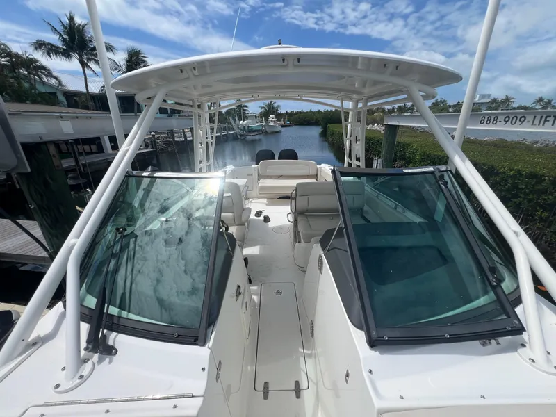 Slide: The Image of 2013 Boston Whaler 270 Vantage boat docked by a scenic waterway. - 44