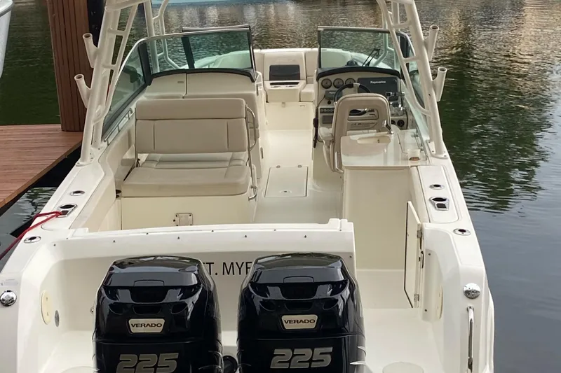 Slide: The Image of 2013 Boston Whaler 270 Vantage boat with dual 225 Verado engines, docked on calm water. - 7