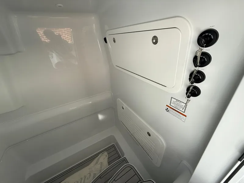 Slide: The Image of Interior view of 2025 Yellowfin 39 Offshore boat, featuring storage compartments and control switches. - 8