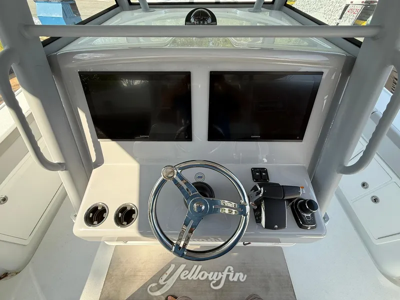 Slide: The Image of 2025 Yellowfin 39 Offshore boat dashboard with dual screens and steering wheel. - 18