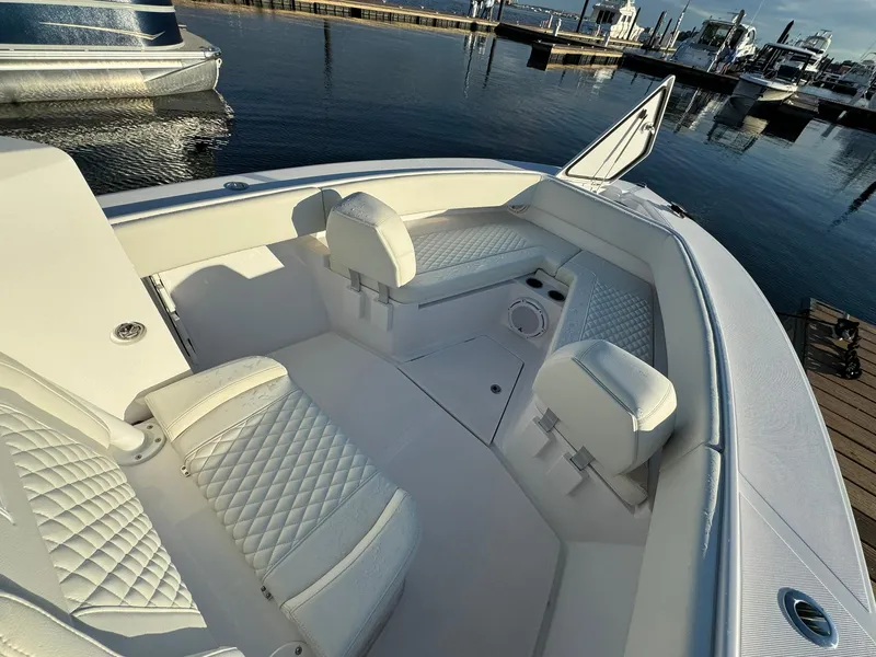 Slide: The Image of 2024 Jupiter 26 FS boat interior with white seating, docked at marina. - 10