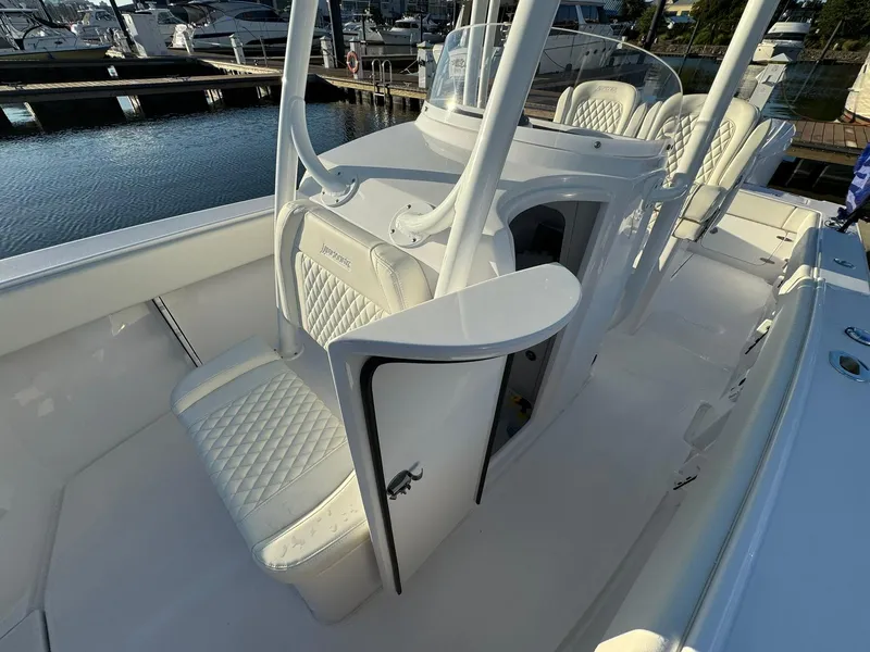 Slide: The Image of 2024 Jupiter 26 FS boat interior with white seating and console, docked at marina. - 13