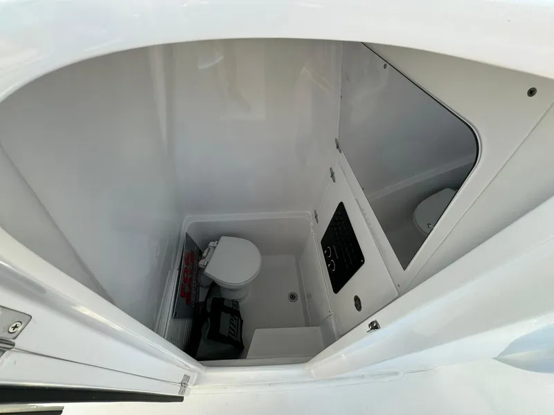 Slide: The Image of 2024 Jupiter 26 FS boat interior with compact marine toilet and storage area. - 14