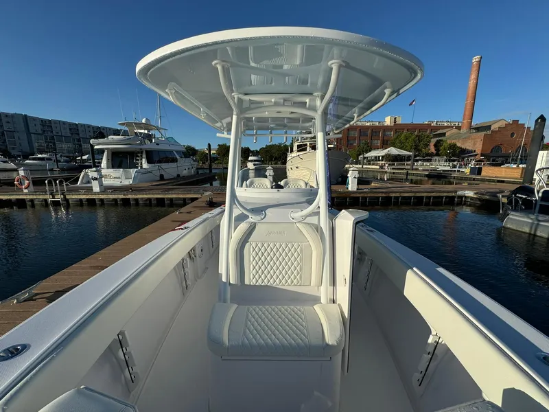 Slide: The Image of 2024 Jupiter 26 FS boat docked at marina, featuring sleek design and spacious seating. - 13