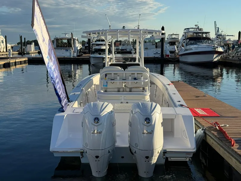 Slide: The Image of 2024 Jupiter 26 FS boat docked with twin engines, marina background. - 22
