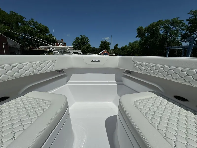 Slide: The Image of 2024 Jupiter 340LS boat interior with white cushioned seating and hexagonal pattern design. - 17