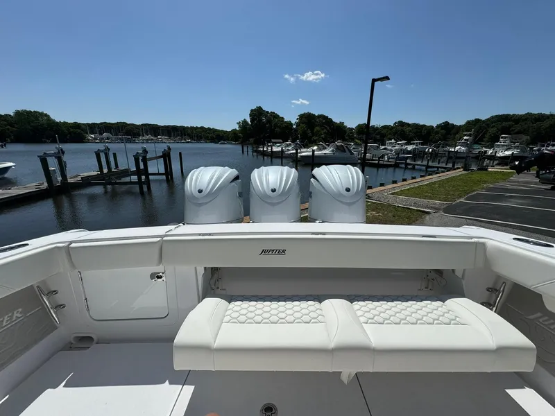 Slide: The Image of 2024 Jupiter 340LS boat with triple engines docked at a marina under clear blue skies. - 30