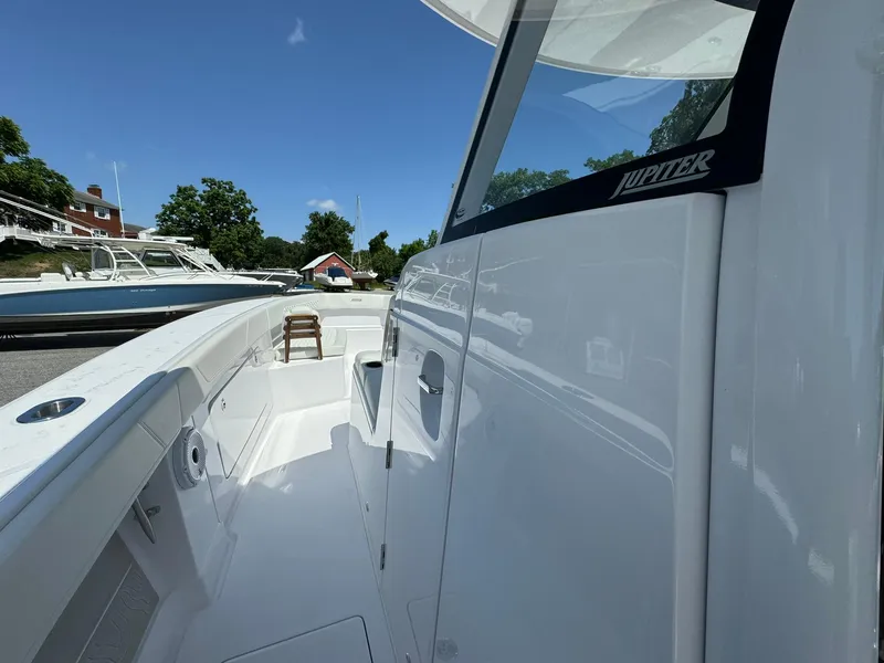 Slide: The Image of 2024 Jupiter 340LS boat, sleek white exterior, docked under clear blue sky. - 15