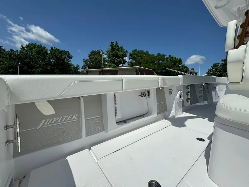 Slide: The Image of 2024 Jupiter 340LS boat interior, featuring sleek white design and spacious seating under a clear blue sky. - 31