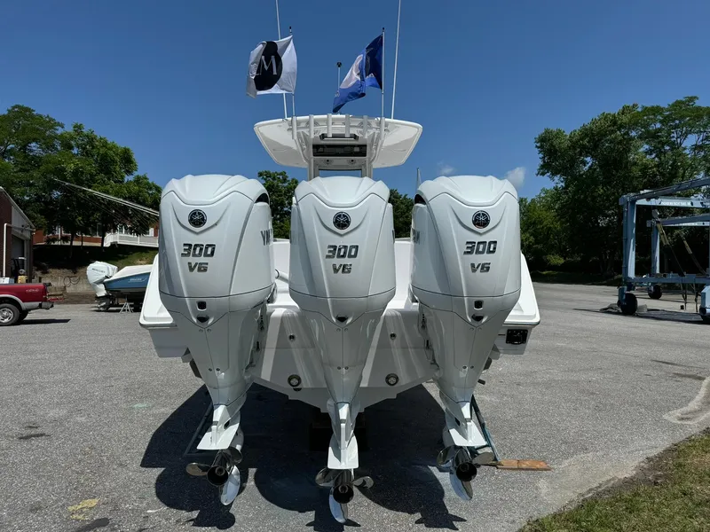 Slide: The Image of 2024 Jupiter 340LS boat with triple 300 V6 engines, docked outdoors. - 6