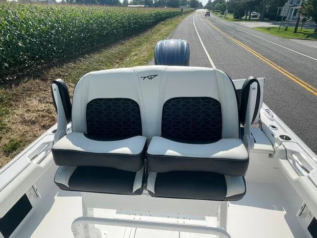 Slide: The Image of 2024 Tidewater 2500 Carolina Bay boat, white deck, sleek design, on a road. - 24