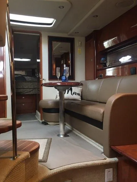 Slide: The Image of Interior of 2004 Sea Ray 390 Sundancer yacht with leather seating and wooden table. - 16