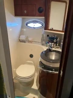 Slide: The Image of Interior of 2004 Sea Ray 390 Sundancer with leather seating and wooden cabinetry. - 19