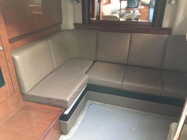 Slide: The Image of 2004 Sea Ray 390 Sundancer interior with built-in TV and wood paneling. - 24