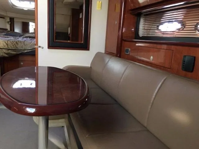 Slide: The Image of 2004 Sea Ray 390 Sundancer interior with white leather seating and embossed logo. - 26