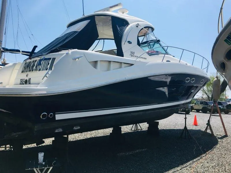 Slide: The Image of 2004 Sea Ray 390 Sundancer boat on dry dock, featuring sleek design and dark blue hull. - 3