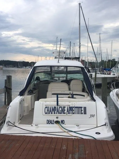 Slide: The Image of 2004 Sea Ray 390 Sundancer docked at marina, rear view with "Champagne Appetite III" name. - 4
