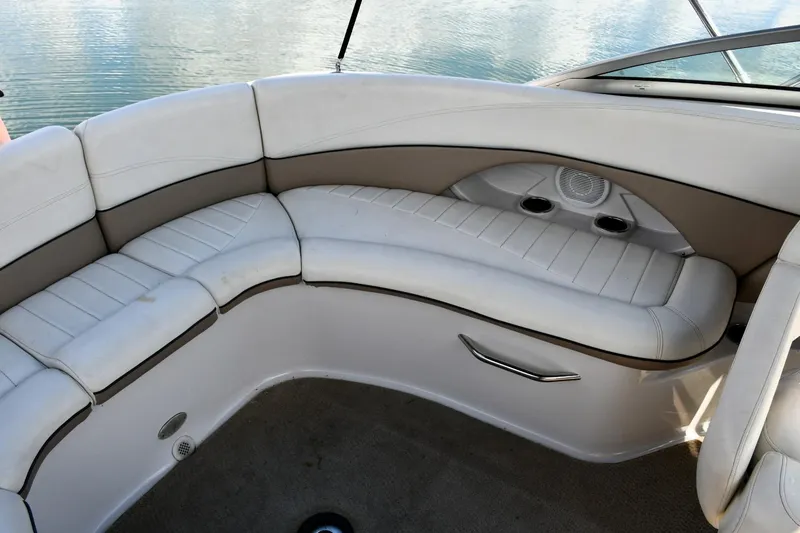 Slide: The Image of 2005 Four Winns 234 Funship boat interior with white cushioned seating and cup holders. - 10