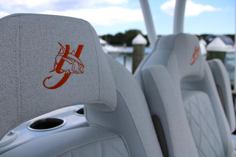 Slide: The Image of 2024 Yellowfin 36 Offshore boat seats with embroidered logo, featuring cup holders and scenic marina backdrop. - 10