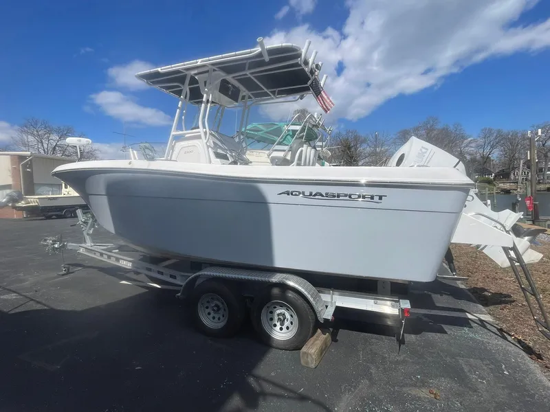 Slide: The Image of 2022 Aquasport 2100 CC boat on trailer under clear sky. - 6
