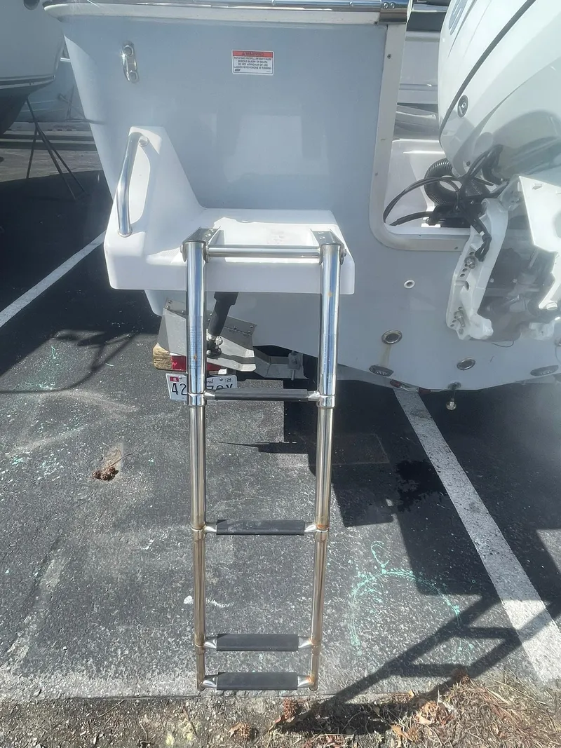 Slide: The Image of 2022 Aquasport 2100 CC boat with a stainless steel swim ladder. - 8