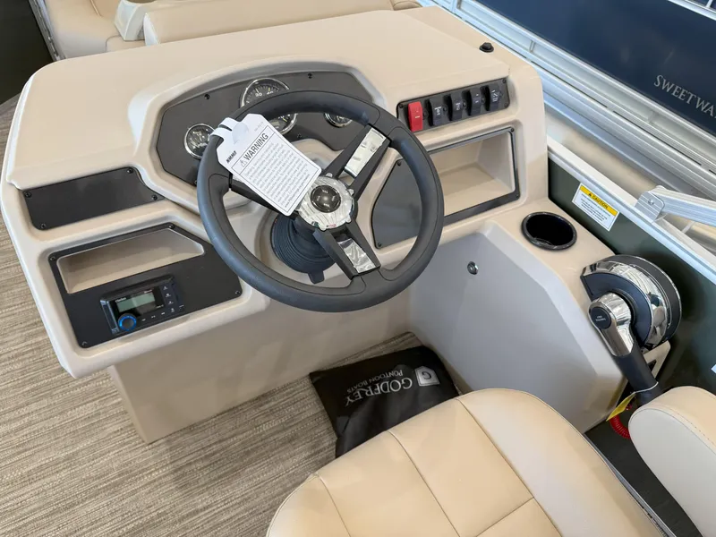 Slide: The Image of 2025 Godfrey EX2086SFLX Tritoon helm with steering wheel, controls, and beige seating. - 11