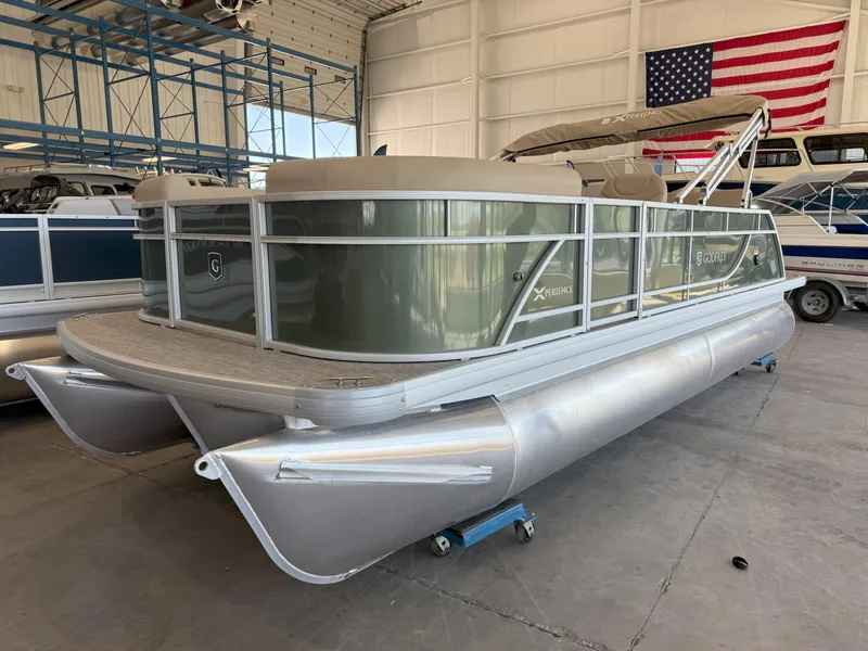 Slide: The Image of 2025 Godfrey EX2086SFLX Tritoon boat in a warehouse with an American flag. - 4