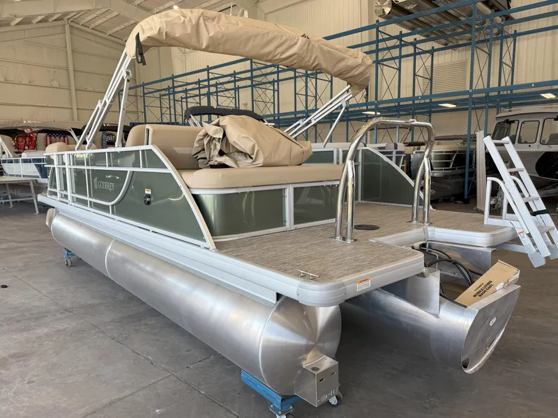 Slide: The Image of 2025 Godfrey EX2086SFLX Tritoon boat in storage, featuring a sleek design and sturdy pontoons. - 5