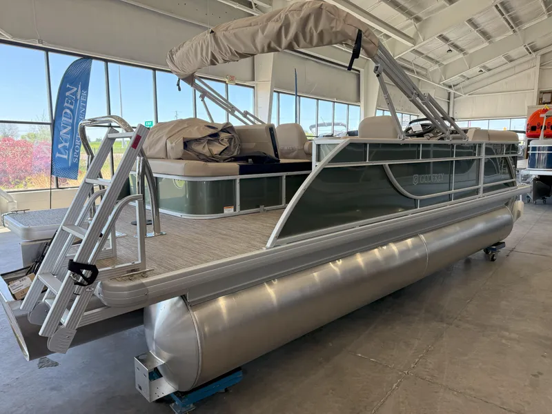 Slide: The Image of 2025 Godfrey EX2086SFLX Tritoon boat in showroom, featuring sleek design and comfortable seating. - 6
