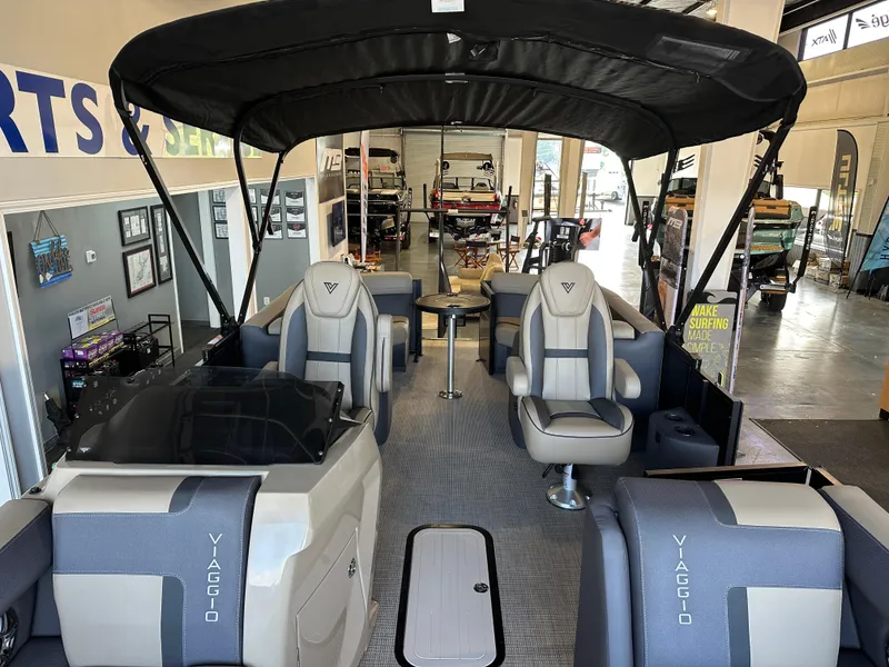 Slide: The Image of 2025 Viaggio Lago X-U pontoon boat interior with seating and canopy in showroom. - 10