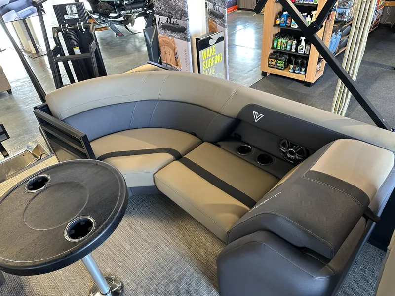 Slide: The Image of Luxurious Viaggio Lago X-U 2025 boat seating with table and cup holders in showroom. - 13